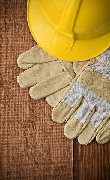View on a hardhat with gloves on wooden board