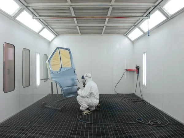 Painter works in a spray booth