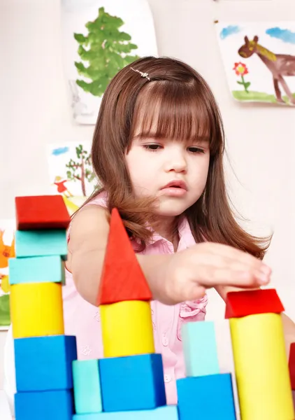 Child playing block in play room.