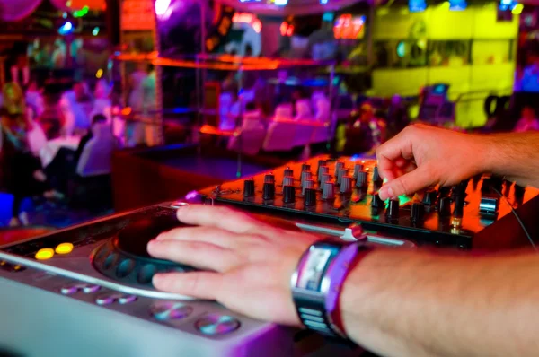 dj mixes the track in the nightclub at a party