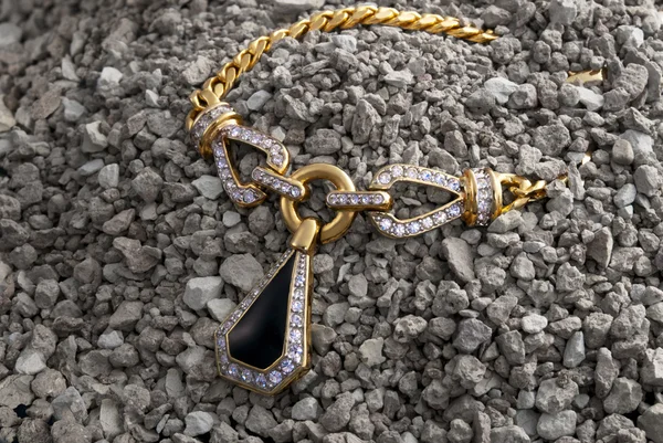 Gold necklace in the pile of pebbles