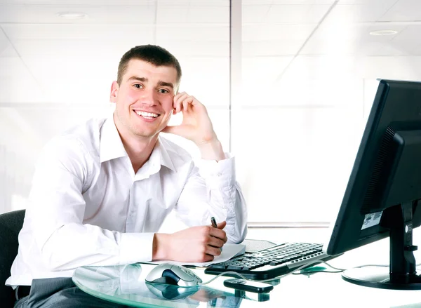 Happy businessman sits at the computer
