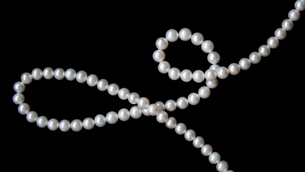 Stock Photo: White pearls on black velvet