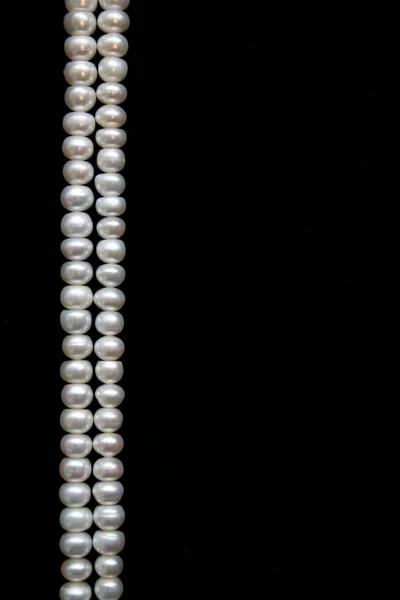 White pearls on the black background