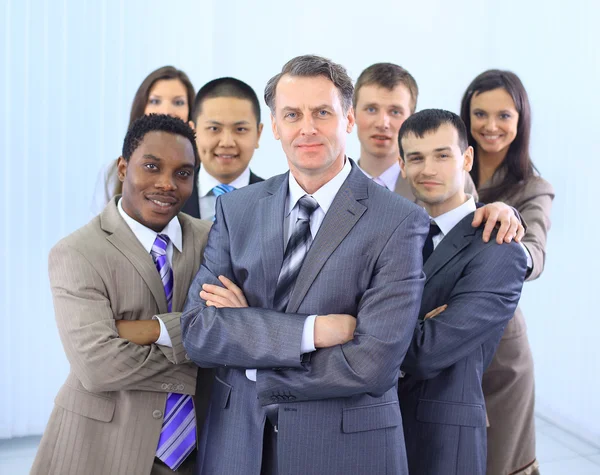 Group of co-workers standing in office space smiling