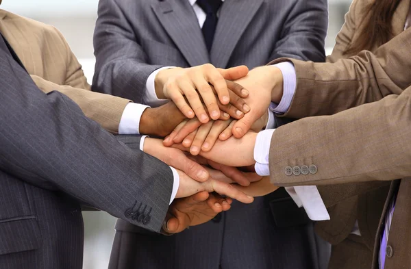 Group of business making a pile of hands in a light and modern offic