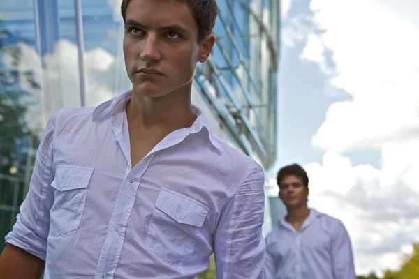 Two attractive man stay near modern business building
