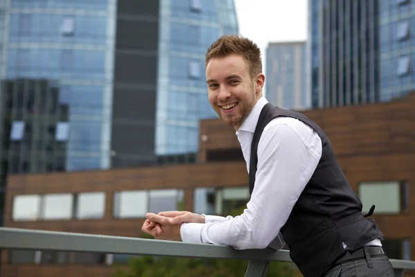 Portrait of a handsome smiling young business man. Outdoor photo.