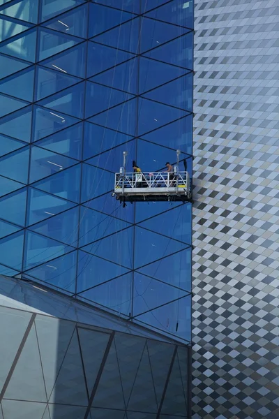 Workers washing the windows facade of a modern office building (cleaning gl