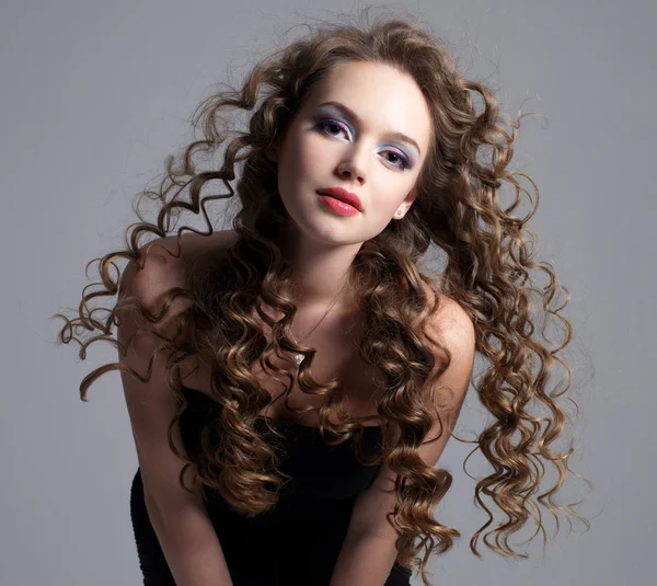Glamour face of teen girl with long curly hair