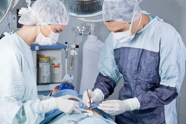 Medical professionals carrying on surgery on patient