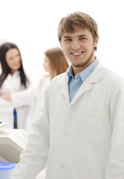Group of scientists working at the laboratory, young doctor smiling at came