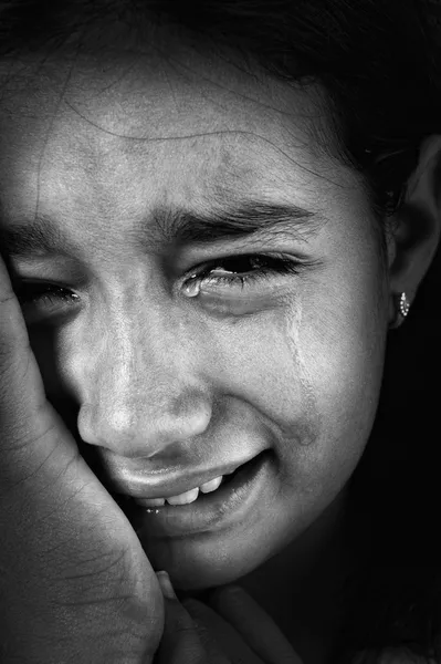 Crying girl, tears on cheeks, low light key, added grain, black and white