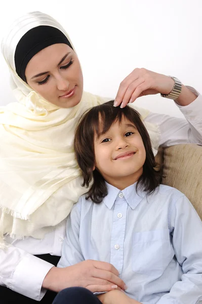 Muslim arabic covered mother and son relaxing at the home