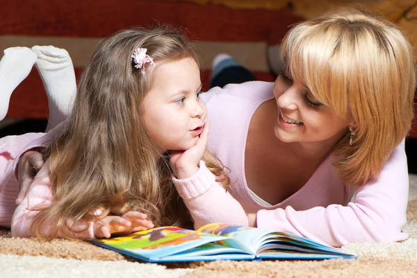 Sweet little girl with mother reading book
