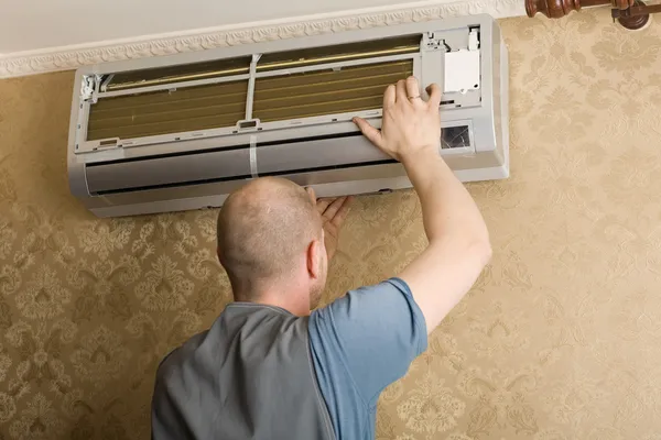 Technician installs a new air conditioner in the apartment