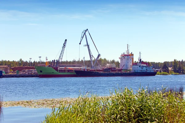 Cargoship unloading on the river Luga. Russia