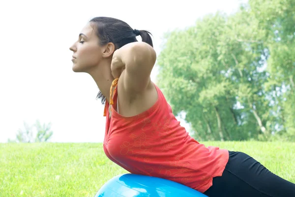 Fitness women exercising with pilates ball outdoors