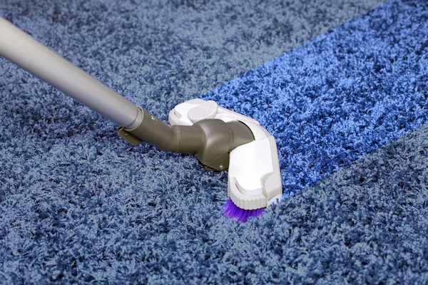 The metal pipe of vacuum cleaner in action -clean a carpet and floor