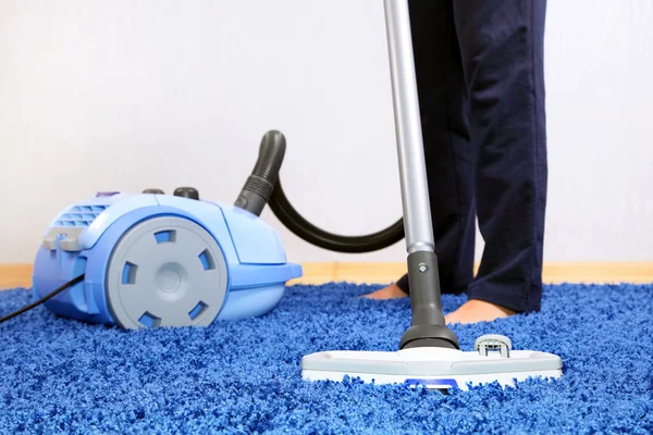 Vacuum cleaner in action - men cleaner a carpet.