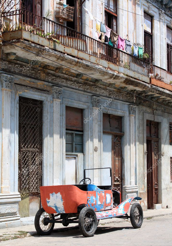 A colourful tattered open top 1912 vintage car in a street of Havana Cuba