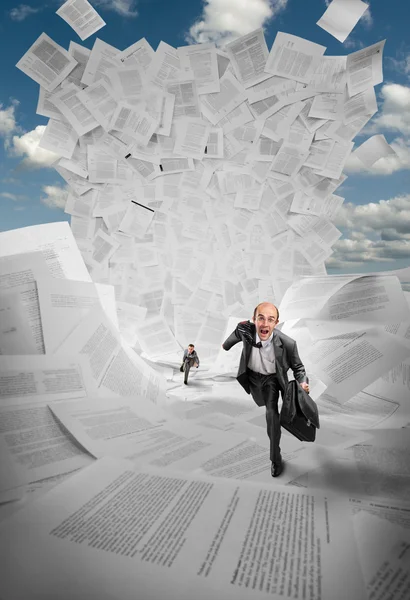 Businessmen running away from wave of documents