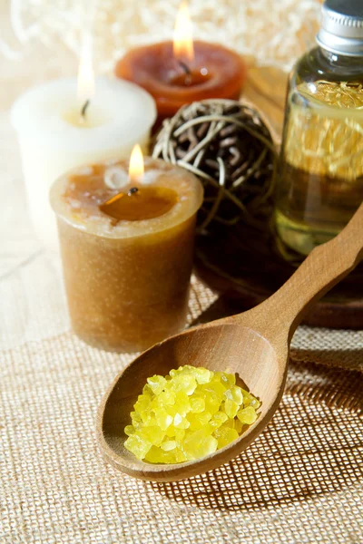 Spa aroma salt in wooden spoon and aroma candles