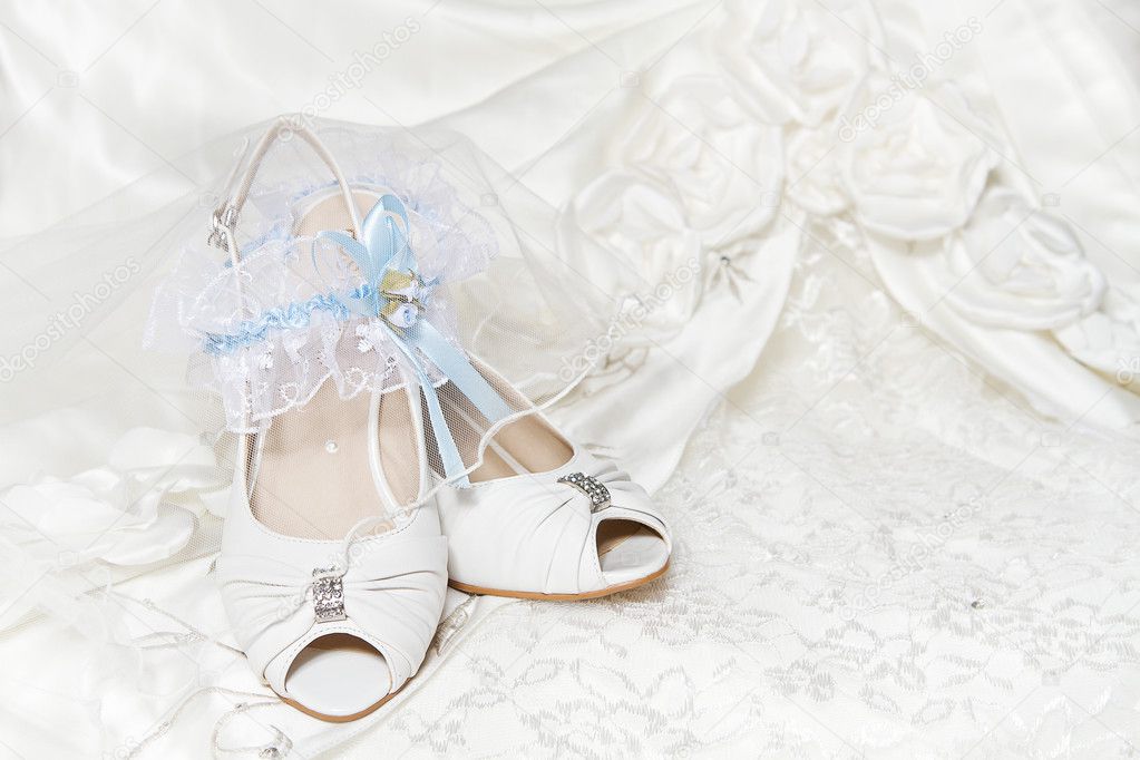 Bride's shoes garter with blue ribbon wedding dress Closeup of wedding