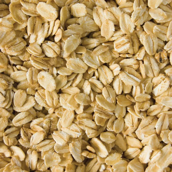 Oatmeal background, rolled raw oats macro closeup