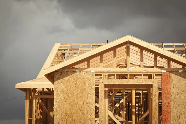 Home Construction Framing with Ominous Clouds