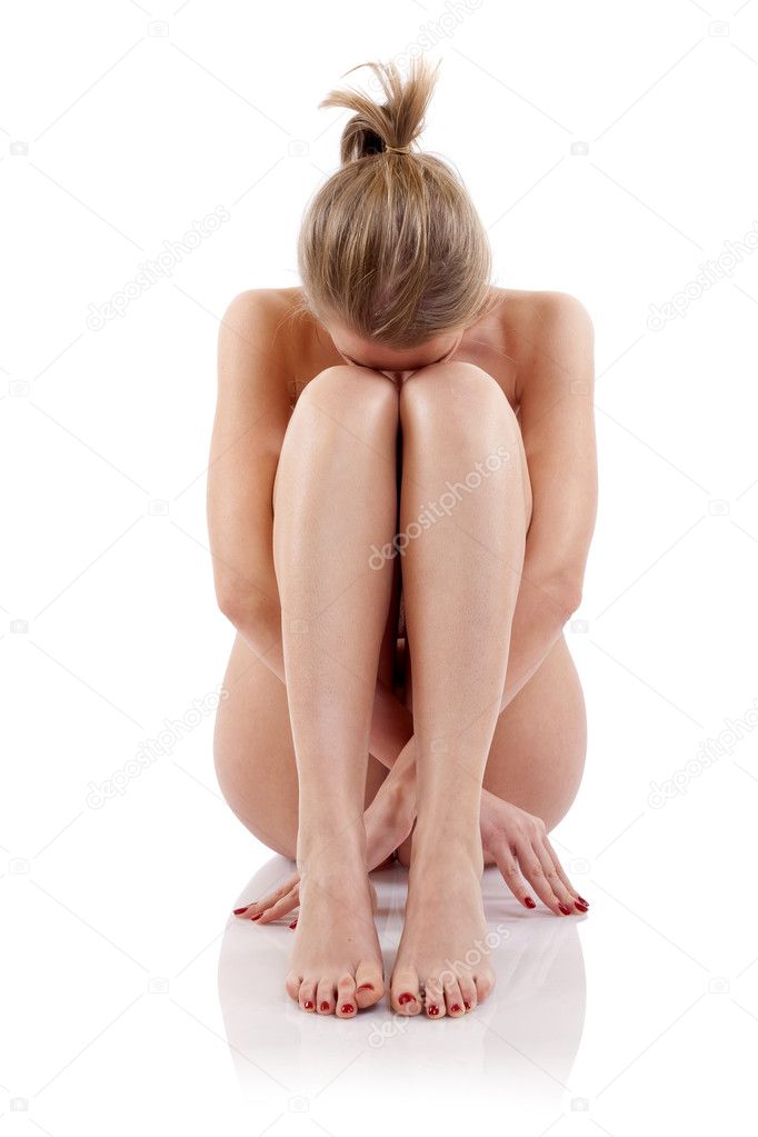 Naked Woman Sitting And Embracing Her Legs Stock Photo