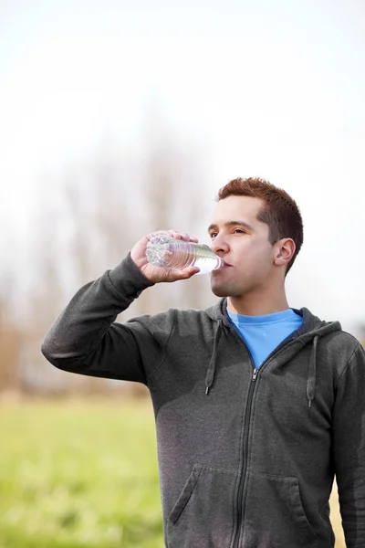Mixed race man drinking water