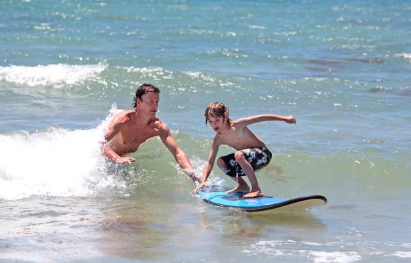 Father teaching his young son to surf