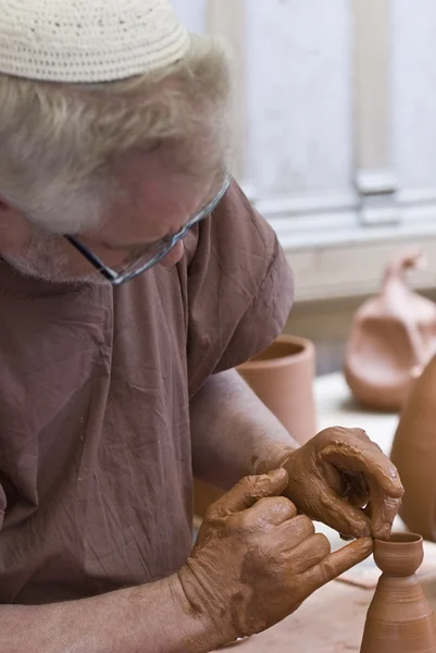 Potter working with his hands.