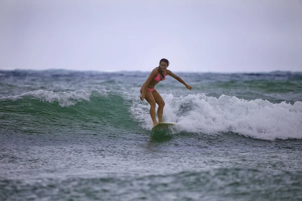 Teenage girl in pink bikini with her surfboard
