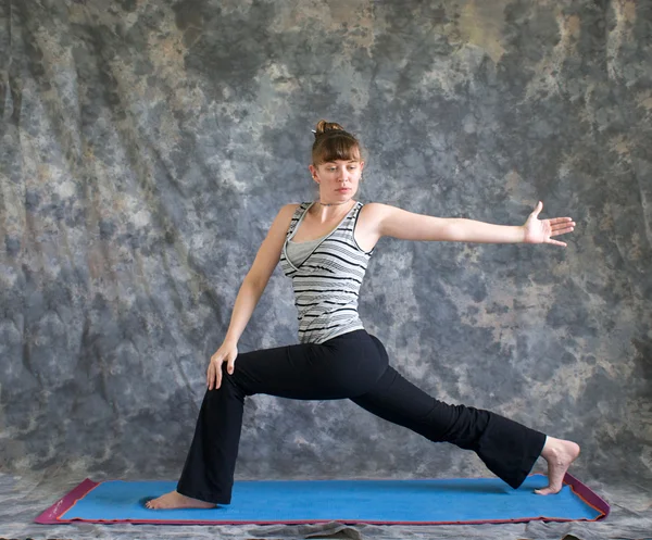Woman doing Yoga posture rotated high lunge