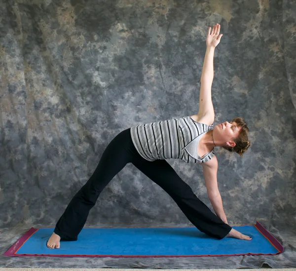 Woman doing Yoga posture Triangle Pose or Trikonasana