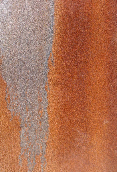 Rusty orange surface with silver paint drip mark