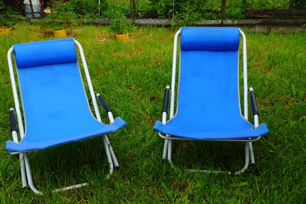 Two folding deck chairs on the grass