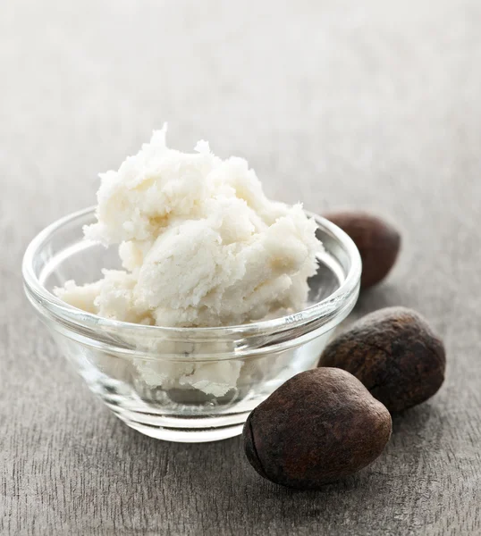 Shea butter and nuts in bowl — Stock Photo #6649285