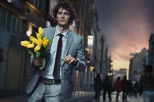 Elegant man holding flowers