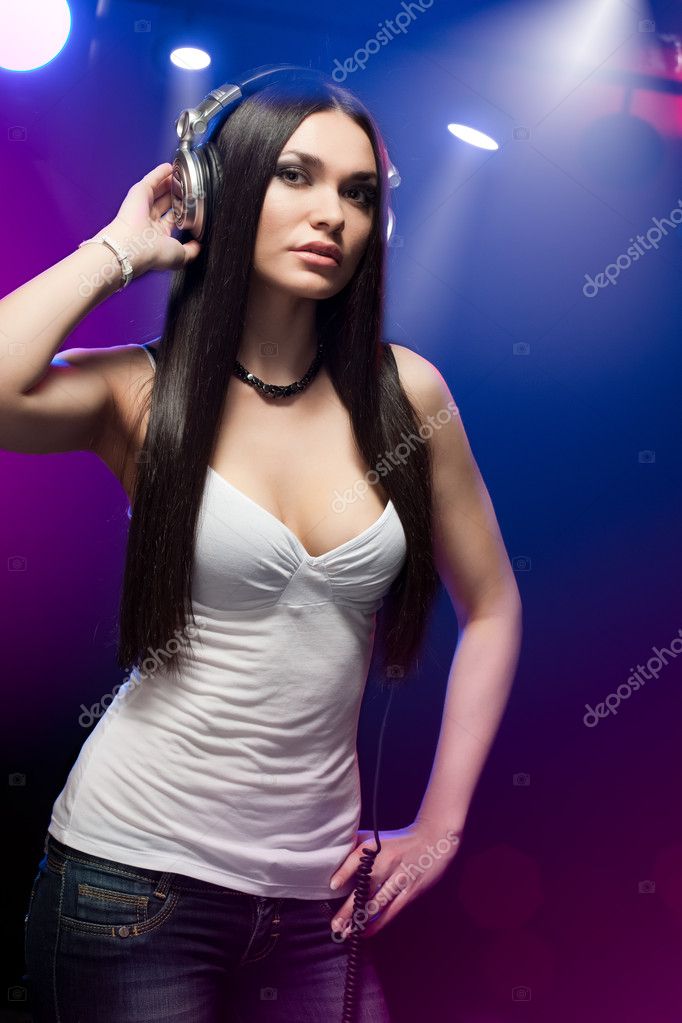 Beautiful woman dj with headphones in the club
