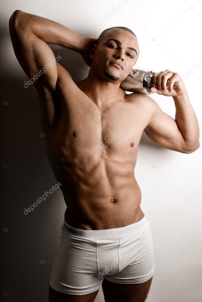 Strong wet sexy nude young bodybuilder posing with bottle | Stock