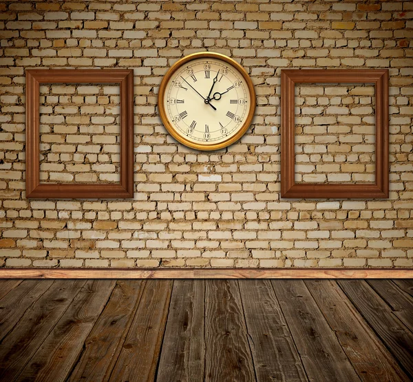 Empty photo frames and wall clock against an wall in old room