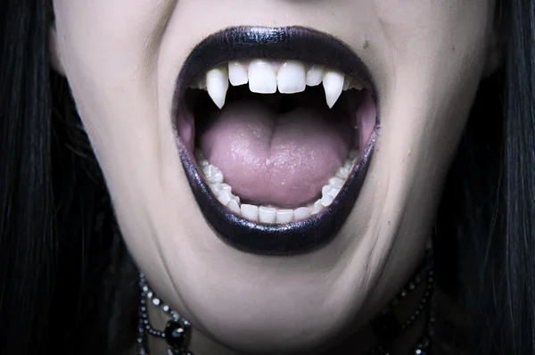 Opened vampire woman mouth closeup