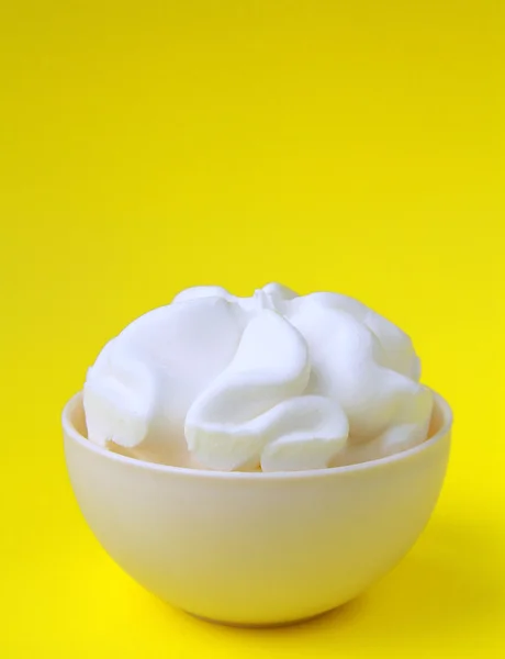 Ice cream in a white cup on yellow background