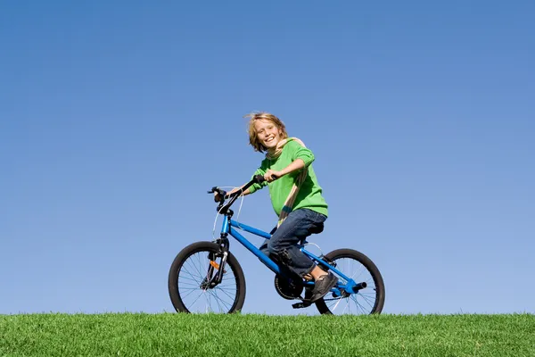 Healthy happy kid playing outdoors riding bike
