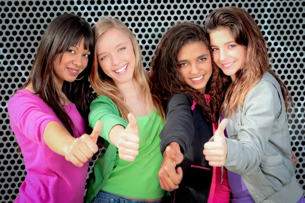 Happy diverse teen girls showing thumbs up
