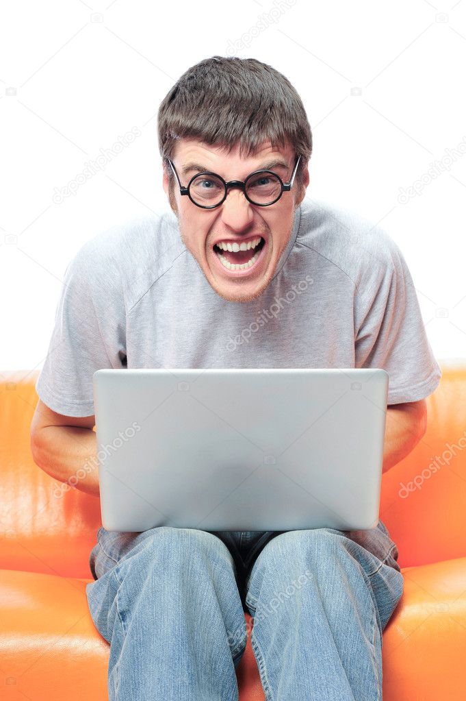  man using laptop and sitting on the sofa wearing round glasses