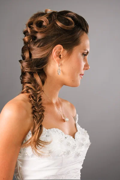 Bridal hairdo with a plate on studio neutral background